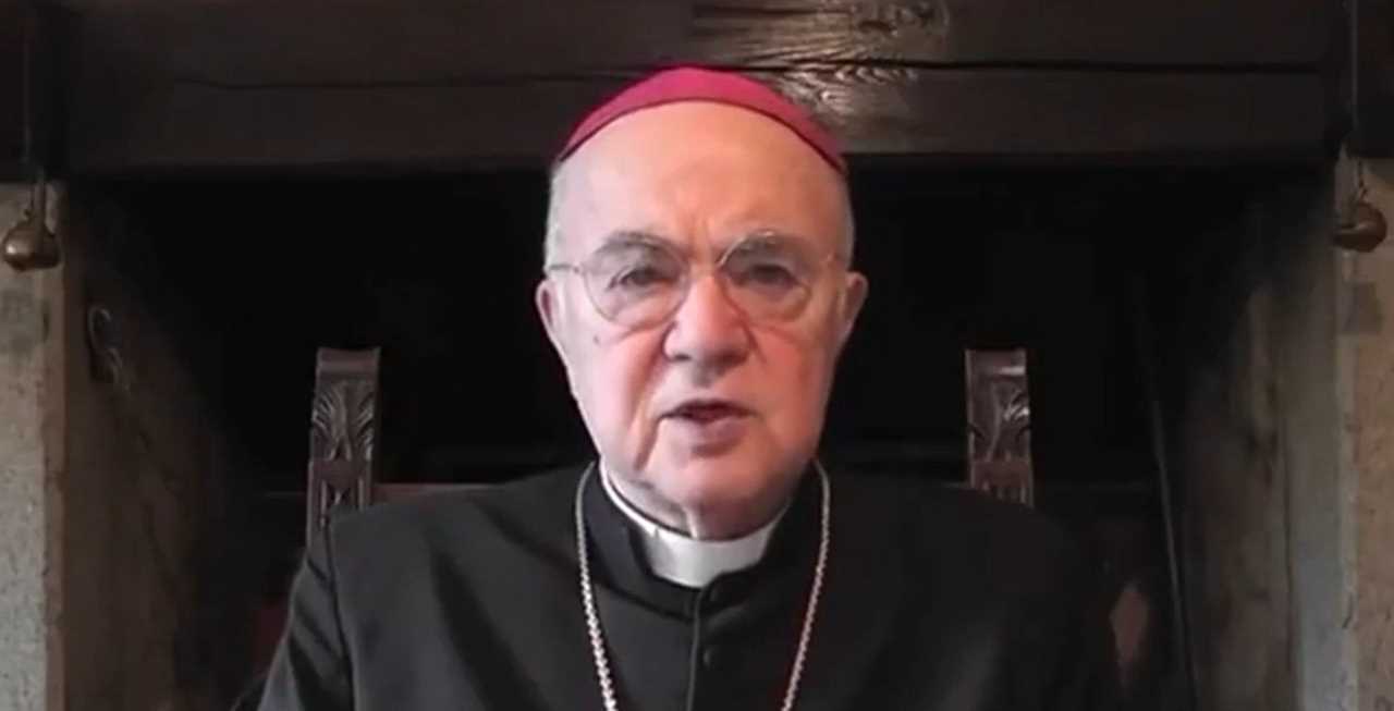 Elderly man in clerical attire speaking from a rustic setting, emphasizing a serious message with a focused expression.