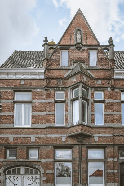 A Glass-Wrapped Living Space Cracks Open a Historic Brick Home in Belgium