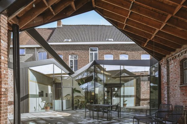 A Glass-Wrapped Living Space Cracks Open a Historic Brick Home in Belgium