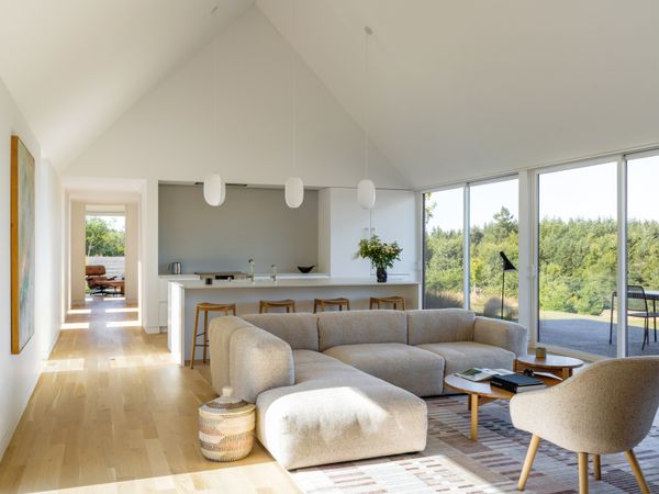 Lawler's mom wanted an all-white kitchen, and he delivered with Caesarstone countertops in Blizzard alongside Venice terrazzo tile from Concrete Collaborative. A Mags Sofa and 82 Armchairs from Hay sit in the living room.