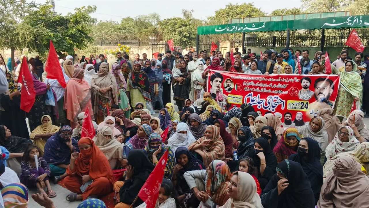A large crowd of people, mostly women, gather for a protest holding banners and flags in support of social justice and political change.