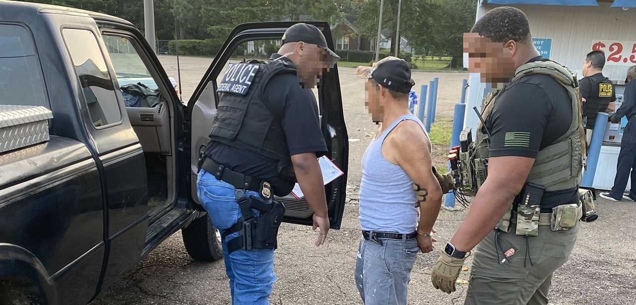 Police officers apprehending a suspect outside a vehicle in a parking lot, showcasing law enforcement activity and public safety efforts.