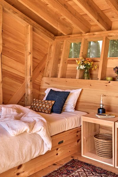 Inside, the back wall angles upward to create a built-in headboard. Furniture is all moveable, and the two single beds can be combined to make a king-sized sleeping arrangement.