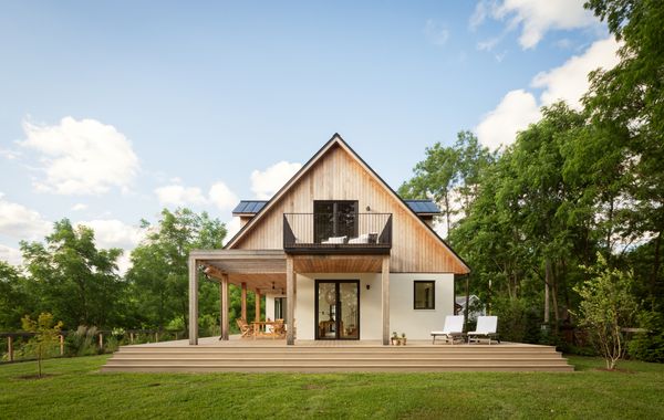 Architect Ravi Raj leaned into the historic character of the neighborhood by designing a large pitched roof for the house. It had the added benefit of providing cover for an outdoor dining space, which connects to the larger wraparound deck.