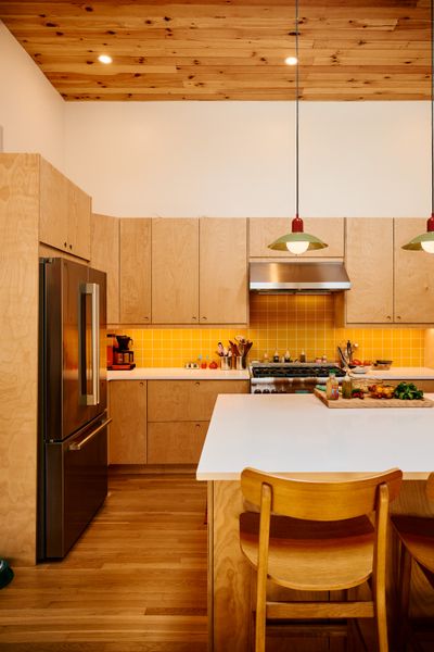 The kitchen is now in the front of the house and features Ikea cabinets with flat plywood fronts, made by Plykea. The circular indents on the face of each function as a handle or drawer pull.