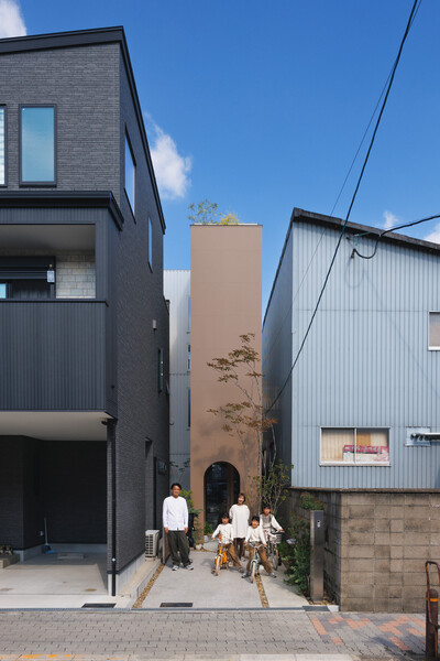 Tsuyoshi and Maya Ohama and their daughters, nine-year-old Nana and seven-year-olds Kano and Yuno, use the narrow strip leading up to their Hirano, Osaka, home as a driveway or, during summer, a spot for their inflatable pool.