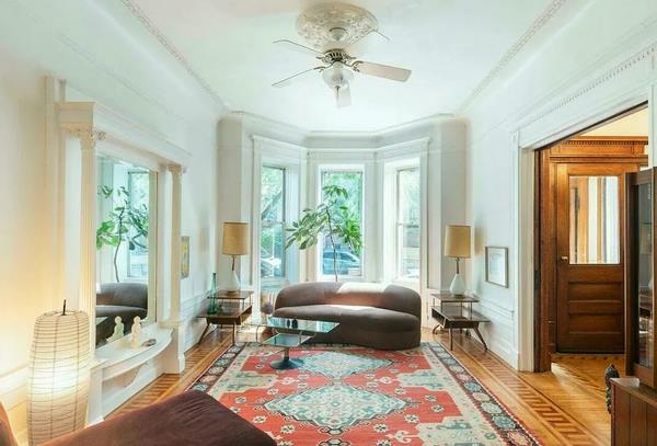 Before: The living room was previously defined by stark white walls and a huge mirror. The cream ceiling fan had to go.