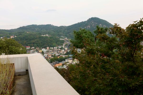 Stitching together small plots of land over the course of more than 10 years, architect Wook Choi, head of Seoul-based One O One Architects, and artist Jinnie Seo created a compound of five structures that support their work and lifestyle, including a building for Jinnie’s archives and open storage. The view from the rooftop terrace of Jinnie’s archive/storage space includes the Seoul cityscape below and Mount Bugak in the distance.