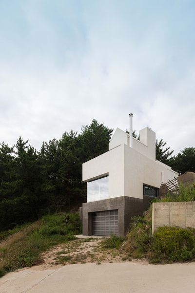 The home consists of three stories nestled into a coastal hillside.