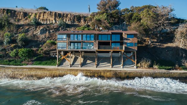 Set below Highway 101 and the Amtrak train line, the cedar-shingled duplex perches on piers anchored to the seawall.