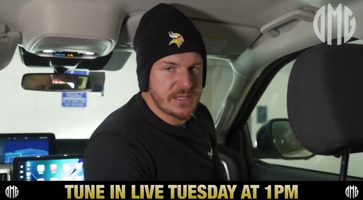 Person wearing a Vikings beanie inside a vehicle, promoting a live event scheduled for Tuesday at 1 PM.