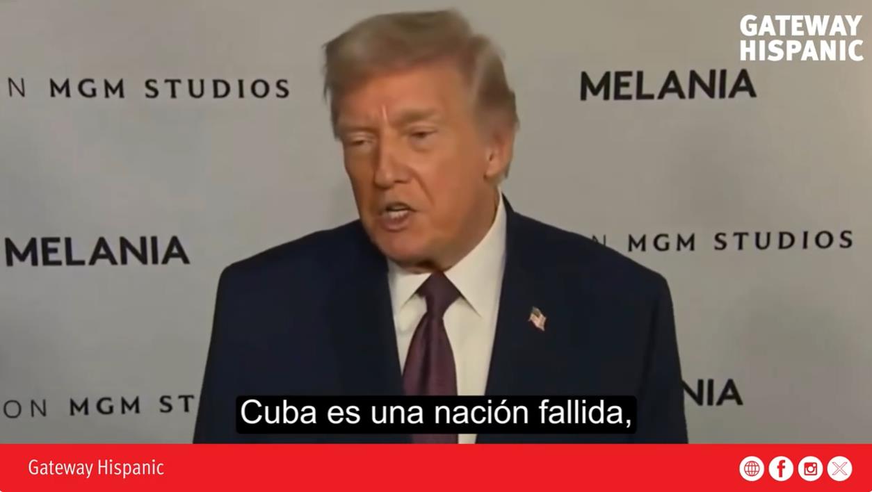 Donald Trump speaking at an event, addressing Cuba as a failed nation, with branded backdrop and captions in Spanish.