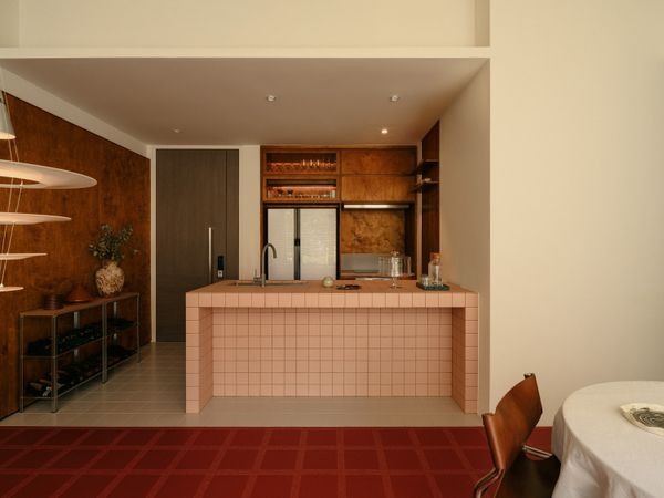 The kitchen counter’s new pink tiles bring an element of playfulness to the scheme. Square floor tiles were also used to define the kitchen from the dining-and-living area.  