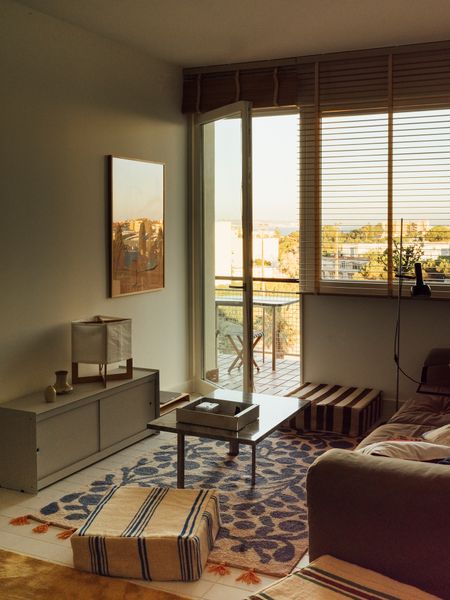 Textiles are a craft the architect couple love. Carpets, like the blue-and-beige Terttu Wool Rug in the living room by Japanese textile artist Eri Shimatsuka, anchor the space. The square poufs are upholstered in Moroccan textiles and the prototype lamp by Elisa Pegorin and Nicola Tuan was given to them as a wedding gift.