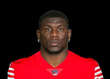 Portrait of a professional football player wearing a red jersey, showcasing a focused expression against a neutral background.