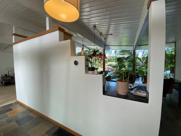 Before: A stepped wall blocked sightlines between the entrance through the atrium, and the window wall at the backyard.