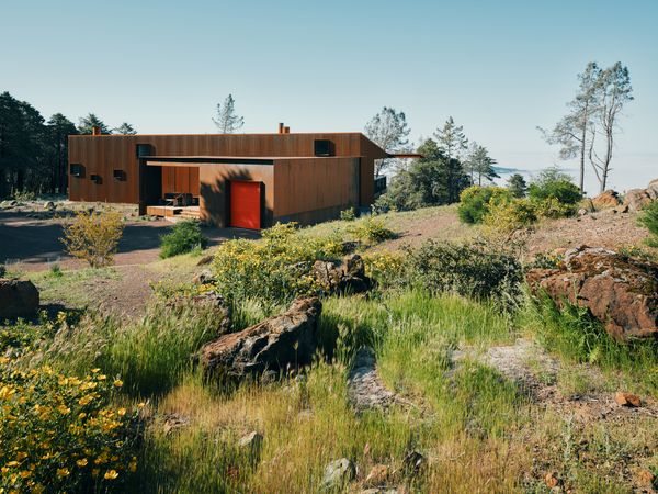 The orange garage door and the yellow entry door reference the color of the surrounding poppies—the first thing to grow back after the fire.