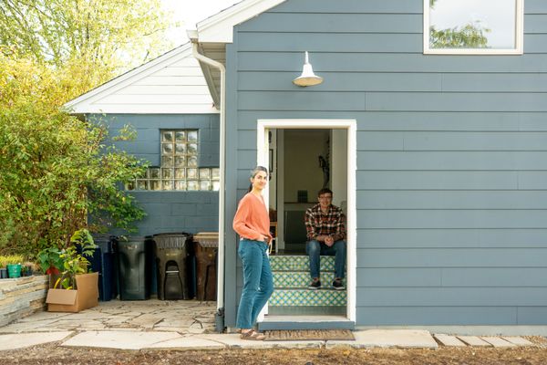 The original house was built with CMU blocks, seen at left. The new addition, where Jessica and Dan are posing, is clad with cement-board panels.