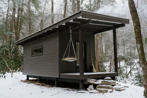A standing-seam metal roof extends over the porch of their 180-square-foot cabin. In the summer, friends taking advantage of the rafting season are happy to sleep outside.