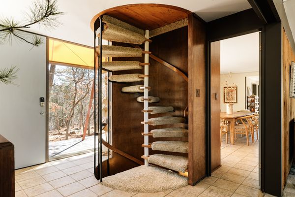 The walnut-paneled spiral staircase seperates the common areas from the bedrooms above.