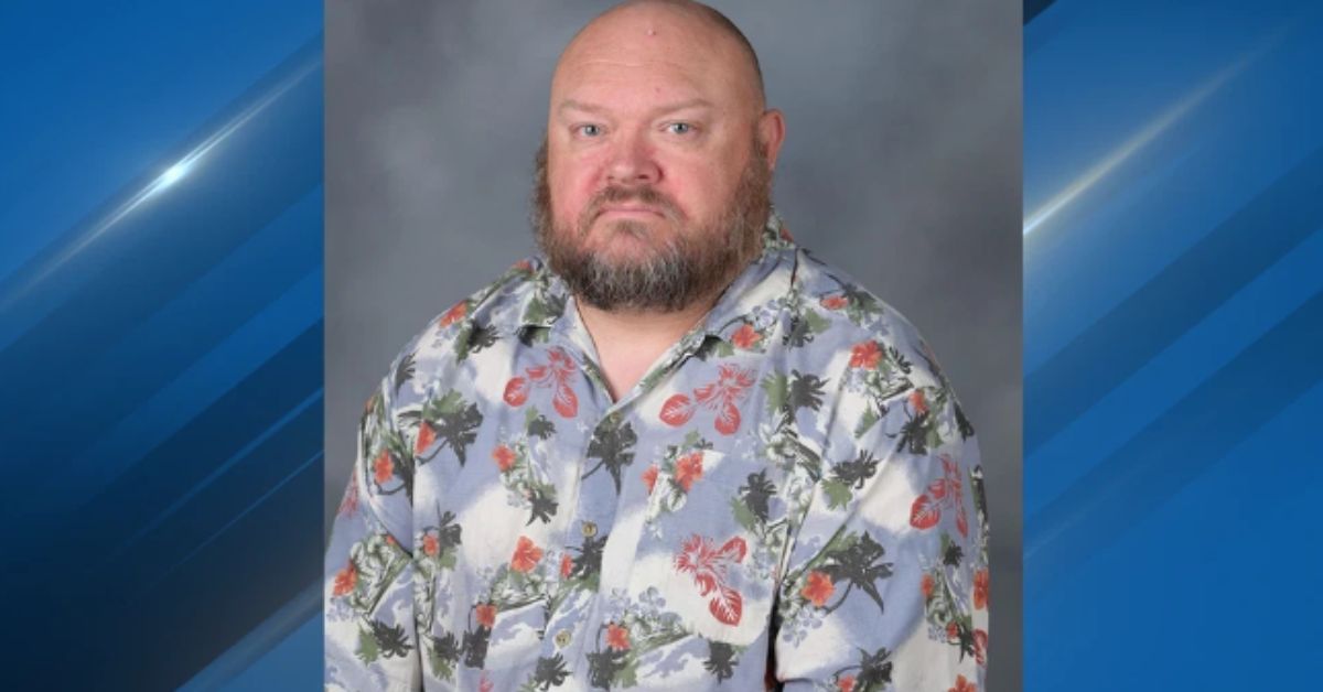 Portrait of a middle-aged man with a beard wearing a colorful floral shirt, set against a neutral background.