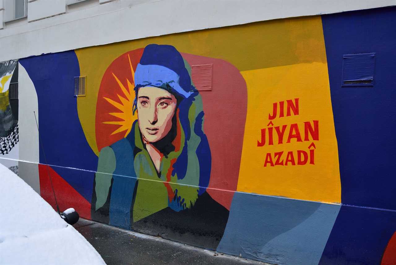 Colorful mural featuring a portrait of a woman with the phrase "Jin Jiyan Azadî," symbolizing women's rights and freedom.