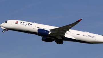 Delta Airlines aircraft in flight against a clear blue sky, showcasing its distinctive livery and modern design.