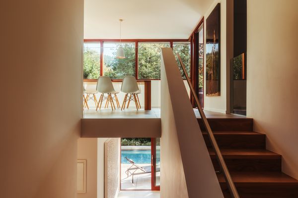 Flooring made from basaltina tiles gives way to a walnut-clad staircase.