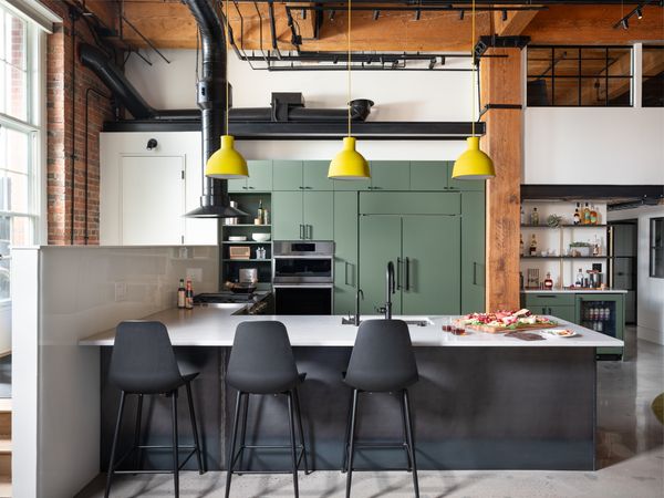 In the kitchen, Unfold Pendants by Muuto hang above the Silestone countertops and Svelti Counter Stools by Article.