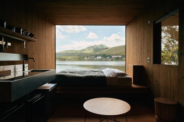 The 275-square-foot home is mostly occupied by the open living area. Opposite the bed, a built-in bench is oriented towards the framed-view of Lake Shirakaba.
