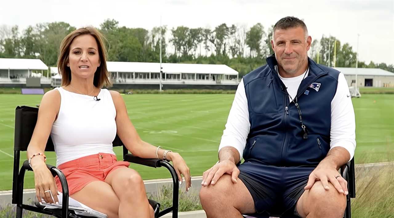Interview between two sports personalities on a football field, discussing training and team strategies in a relaxed outdoor setting.