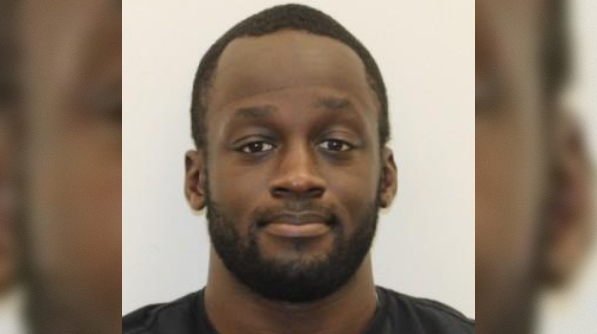 Portrait of a man with a beard and short hair, smiling against a plain white background.