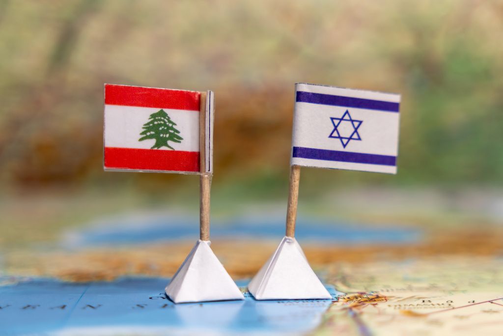 Miniature flags of Lebanon and Israel on a map, symbolizing the geopolitical relationship between the two countries.