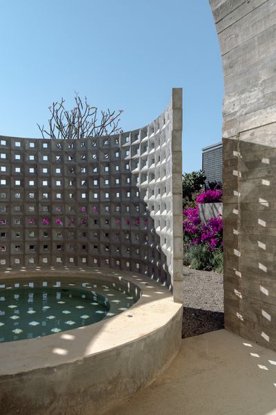 An outdoor spa screened by breeze blocks extends off the bathroom in the primary suite.