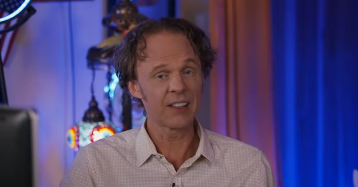 Man speaking in a studio setting with colorful lights and decorative lamps in the background, discussing a topic related to creativity or innovation.