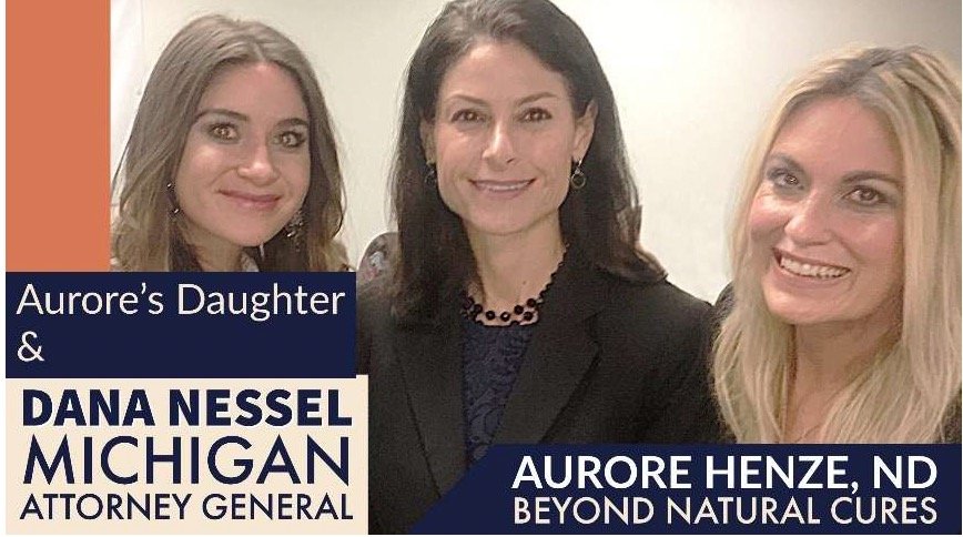 Aurore Henze, ND, poses with Michigan Attorney General Dana Nessel and Aurore's daughter at a public event promoting natural health and wellness.
