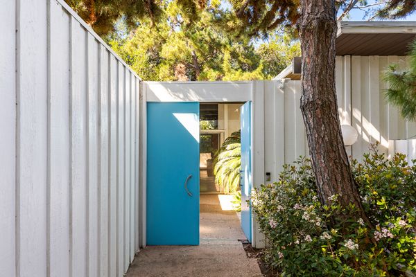 You enter the home through a courtyard behind the teal blue door.