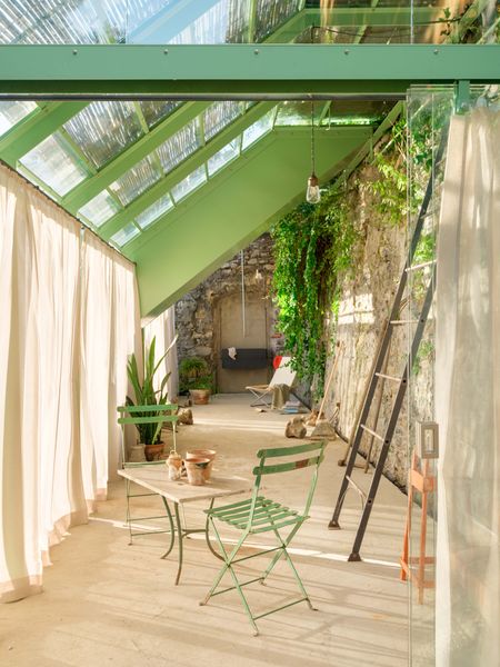 Operable roof panels and bamboo blinds provide cooling and shade for the greenhouse-like structure, which is outfitted with a slate sink, Nychair X chair, and built-in storage.