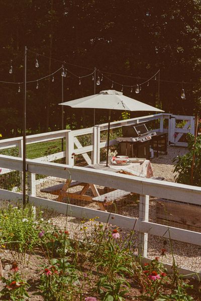 The vegetable garden, picnic table dining area, and barbecue zone are all contained by a fence.
