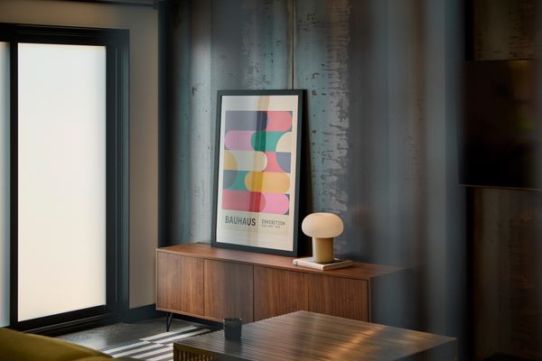 A wood credenza leans against the blackened feature wall.