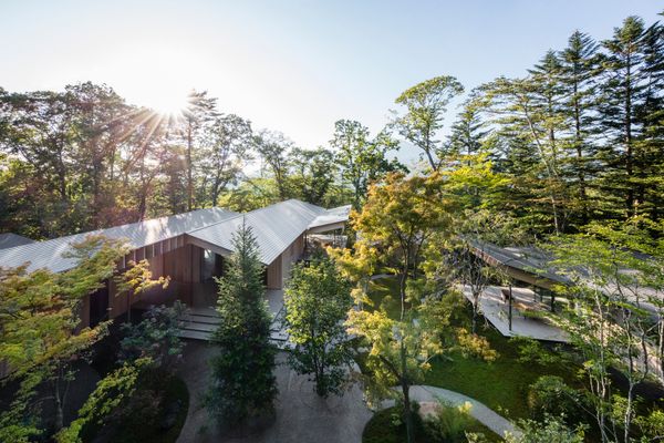 Completed in 2016 and designed by Kengo Kuma & Associates, the 0.6-acre property comprises a main residence and three detached guesthouses, creating what the listing describes as a private village within the forest.