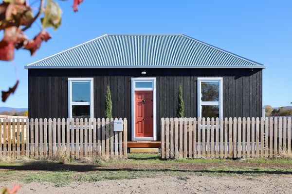 The modest home is clad in Weathertex panels made from 97% eucalyptus woodchips and 3% paraffin. The cladding is finished with a charcoal-colored stain to enhance street appeal and avoid any unsightly weathering.
