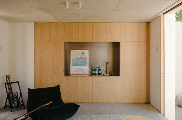 Joinery hides the laundry on the studio's ground floor, and a stainless-steel sink turns the room into a bar when the family hosts. Linear Standard handles finish the cabinetry.