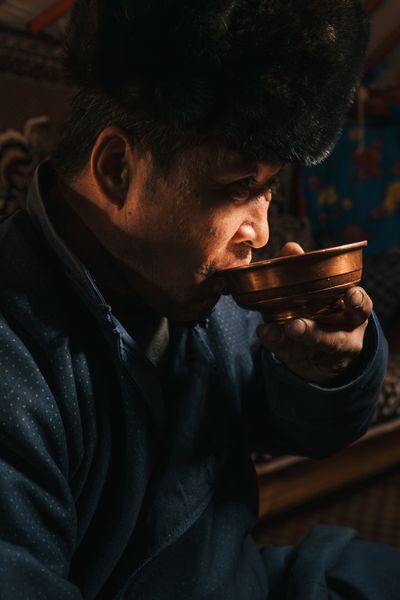 Guests are typically offered a shared serving of <i>airag </i>(a traditional fermented milk) or <i>arkhi</i> (a clear, vodka-like alcohol). Munkhjargal Damrindorj (pictured), who lives with his wife, Javkhlan Baldandorj, between a ger in the remote Tsawchir Had area near Ömnögovi Province’s northern border during winter and a small house in summer, drinks arkhi from a copper bowl.